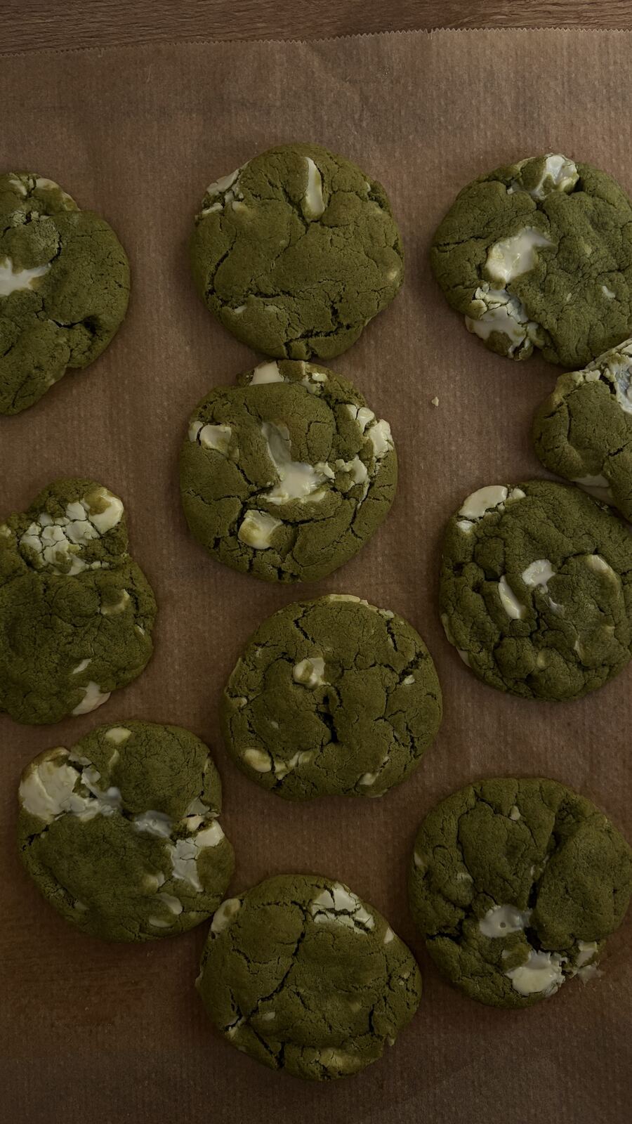 Selbstgebackene Matcha-Cookies mit weißer Schokolade auf Backpapier